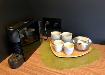 black coffee machine with capsules and white coffee cups